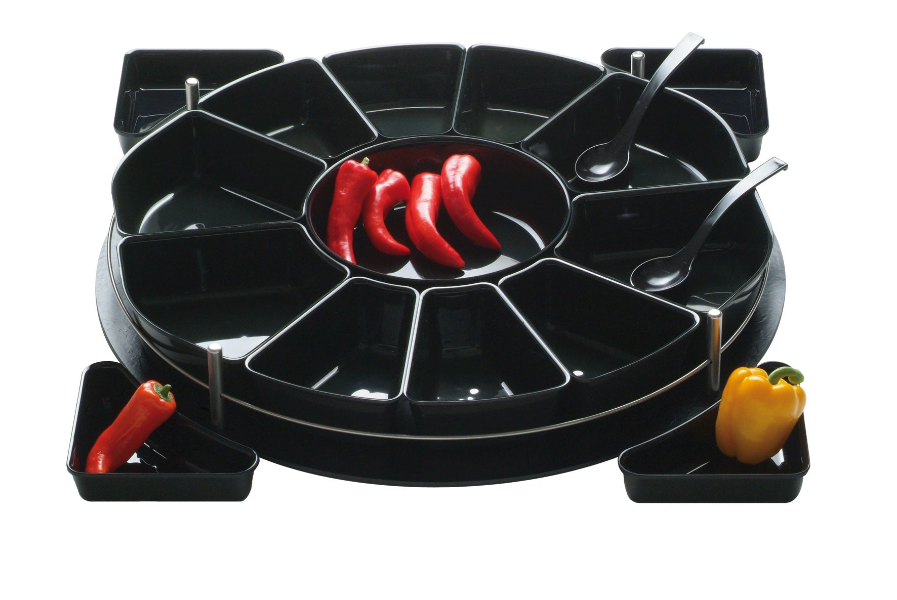 Schwarze runde Ablage mit schwarzen Einlageschalen, die im Kreis angeordnet sind. Einige sind mit Paprika und Peperoni befüllt. 