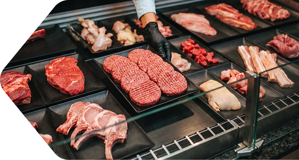 Thekenpräsentation von Fleischwaren in schwarzen Thekenschalen.