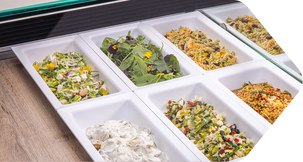 Weiße Thekenschalen mit Salat und Feinkost